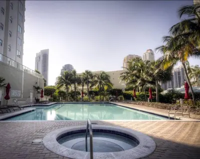 a large swimming pool with palm trees and buildings at Le Marina Bay 409 STR -02439 in Sunny Isles Beach