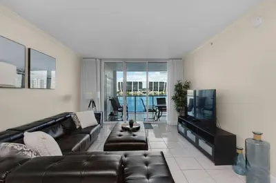 a living room with a leather couch and a flat screen tv at Le Marina Bay 409 STR -02439 in Sunny Isles Beach