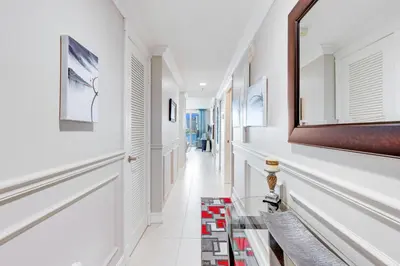 a hallway with white walls and a mirror on the wall at Le Marina Bay 505 STR-02744 in Sunny Isles Beach