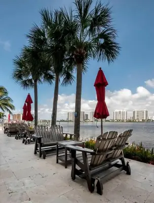 a row of chairs and umbrellas on a beach at Le Marina Bay 603 STR-02736 in Sunny Isles Beach