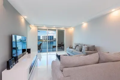 a living room with two couches and a flat screen tv at Le Marina Bay 701 STR-01254 in Sunny Isles Beach