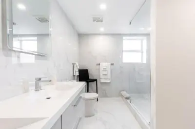 a white bathroom with a toilet and a shower at Le Marina Bay 701 STR-01254 in Sunny Isles Beach
