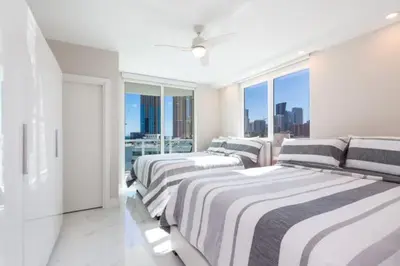 a white room with three beds and a large window at Le Marina Bay 701 STR-01254 in Sunny Isles Beach