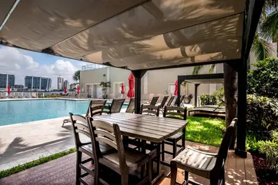 a table and chairs on a patio next to a pool at Le Marina Bay 701 STR-01254 in Sunny Isles Beach