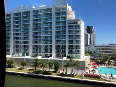 a large building with a pool in front of a city at Le Marina Bay 701 STR-01254 in Sunny Isles Beach