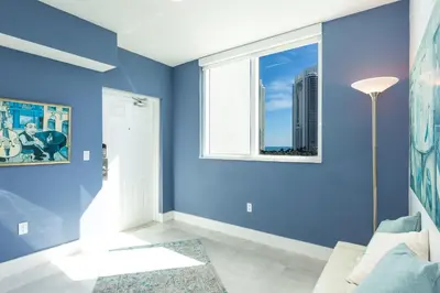 a living room with blue walls and a window at Le Marina Bay 801 STR-01477 in Sunny Isles Beach