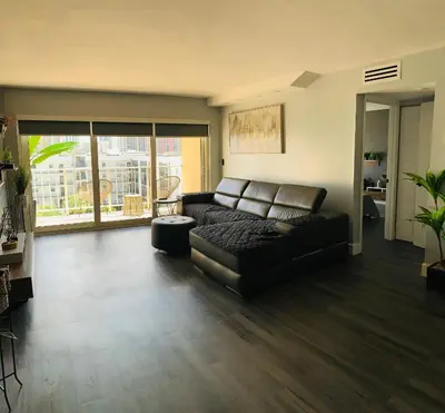 a living room with a leather couch and a large window at Marbella Tower 706 STR-02489 in Sunny Isles Beach