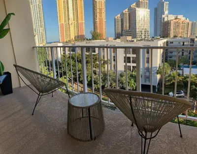a balcony with two chairs and a view of a city at Marbella Tower 706 STR-02489 in Sunny Isles Beach