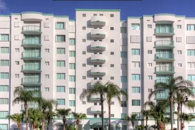a large white building with palm trees in front of it at Le Montcalm 102 STR-01921 in Sunny Isles Beach