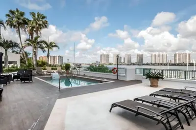 a patio with chairs and a swimming pool on a building at Le Montcalm 102 STR-01921 in Sunny Isles Beach