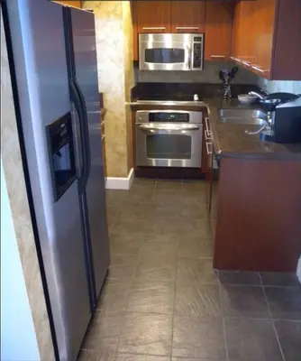 a kitchen with a stainless steel refrigerator and appliances at Le Montcalm 102 STR-01921 in Sunny Isles Beach