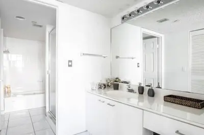 a white bathroom with a sink and a mirror at Le Montcalm 303 STR-01919 in Sunny Isles Beach