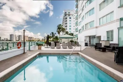a swimming pool with chairs and a building at Le Montcalm 303 STR-01919 in Sunny Isles Beach