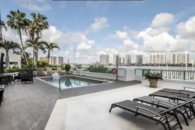 a patio with chairs and a pool on top of a building at Le Montcalm 601 STR-01927 in Sunny Isles Beach