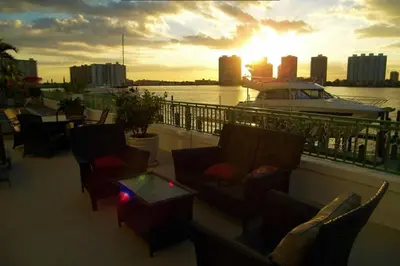 a balcony with chairs and a boat on the water at Le Montcalm 601 STR-01927 in Sunny Isles Beach