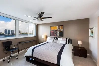 a bedroom with a bed with a ceiling fan and a desk at Le Montcalm 804 STR-01923 in Sunny Isles Beach