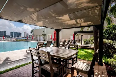a table and chairs on a patio next to a pool at Le Marina Bay PH3 STR-01487 in Sunny Isles Beach