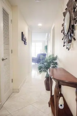 a hallway with a table and a clock on the wall at Le Marina Bay PH5 STR-01500 in Sunny Isles Beach