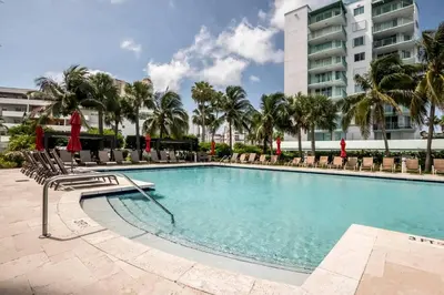a swimming pool with chairs and a building at Le Marina Bay PH5 STR-01500 in Sunny Isles Beach