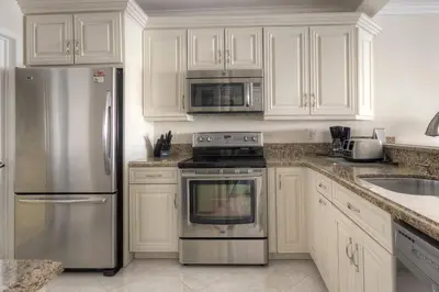a kitchen with white cabinets and stainless steel appliances at Le Marina Bay PH5 STR-01500 in Sunny Isles Beach