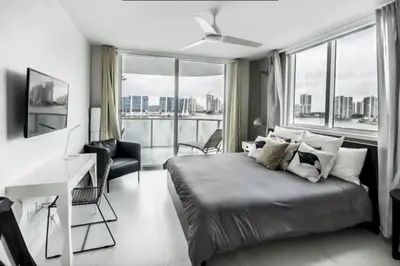 a bedroom with a bed with a desk and a window at Le Marina Bay 810 STR-01434 in Sunny Isles Beach