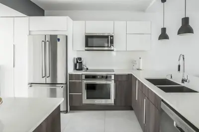a kitchen with stainless steel appliances and wooden cabinets at Le Marina Bay 810 STR-01434 in Sunny Isles Beach