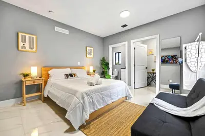 a bedroom with a large bed and a chair at Comfy Studio W Essentials Near Airport in Miami