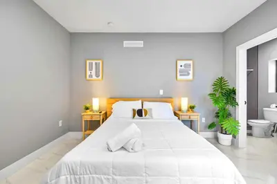 a white bedroom with a large bed and a toilet at Comfy Studio W Essentials Near Airport in Miami