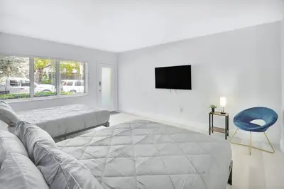 a bedroom with a bed and a couch and a tv at Beachside Escape with King Bed plus 2 Queens Miami in Miami Beach