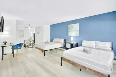 a bedroom with two beds and a blue wall at 1BR Miami Beach Apt with King plus 2 Queens & Smart TV in Miami Beach