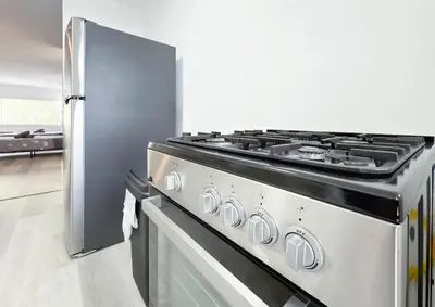 a stove in a kitchen next to a refrigerator at 1BR Miami Beach Apt with King plus 2 Queens & Workspace in Miami Beach