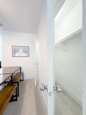 a dining room with white walls and a table and bench at 1BR Miami Beach Apt with King plus 2 Queens & Workspace in Miami Beach