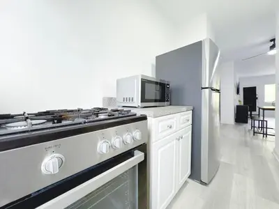 a kitchen with a stove and a microwave at 1BR Miami Beach Apt with 3 Queens plus Free Parking in Miami Beach
