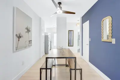 a dining room with a table and a blue wall at 1BR Miami Beach Apt with King plus 2 Queens & Parking in Miami Beach