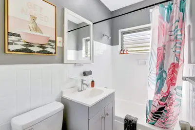 a bathroom with a sink and a toilet and a mirror at Modern Miami Beach Studio with King Bed in Miami Beach