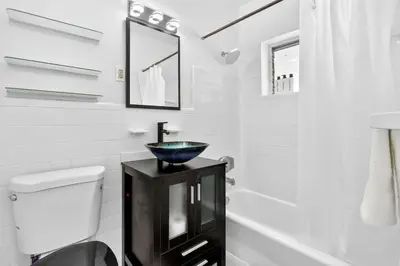 a bathroom with a bowl sink on a black cabinet at Sunny Miami Beach Studio with 2 Queens plus Workspace in Miami Beach