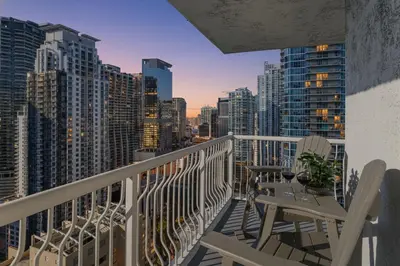 a balcony with chairs and tables and a city skyline at Sky-High Luxury 3BR with Stunning Brickell City & Bay Views in Miami