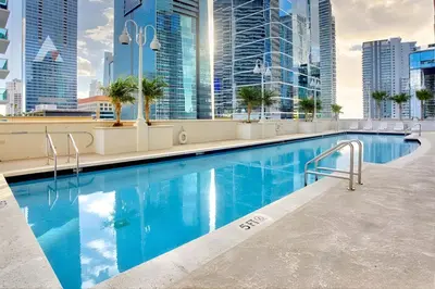 a swimming pool on the roof of a building with tall buildings at Sky-High Luxury 3BR with Stunning Brickell City & Bay Views in Miami