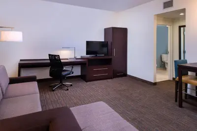 a living room with a couch and a desk with a computer at Residence Inn by Marriott Miami West/FL Turnpike in Miami