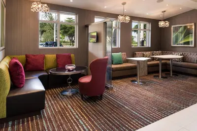 a waiting room with a couch and tables and windows at Residence Inn by Marriott Miami West/FL Turnpike in Miami