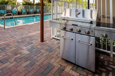 a grill on a patio next to a swimming pool at Residence Inn by Marriott Miami West/FL Turnpike in Miami