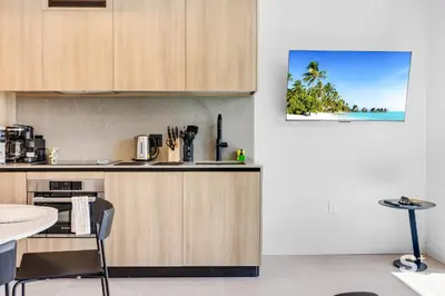 a kitchen with a table and a counter top with a picture of a beach at Downtown Miami - Luxury Condo with City Views in Miami