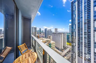 a balcony with two chairs and a view of a city at Cozy and Spacious Studio in Miami City Views in Miami