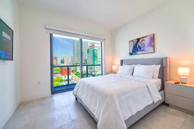 a bedroom with a large bed and a large window at Modern Escape in Brickell w Pool & Gym in Miami