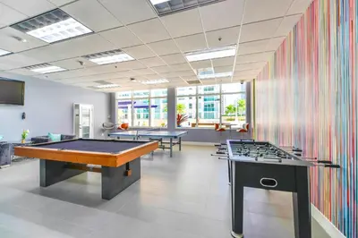 a room with two billiard tables and a colorful wall at Bright Escape Near Hot Spots in Miami
