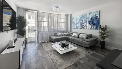 a living room with a couch and a table at Great 2BR Condo-DIRECT BEACH ACCESS Pool, Gym and FREE Parking in Hollywood