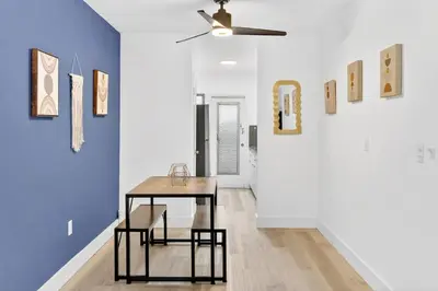 a table and chairs in a room with paintings at Cozy Miami Beach Studio with 2 Queens plus Workspace in Miami Beach