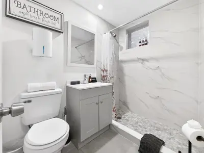 a white bathroom with a toilet and a shower at Cozy Miami Beach Studio with 2 Queens plus Workspace in Miami Beach