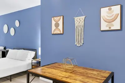 a room with a table and a blue wall at Cozy Miami Beach Studio with 2 Queens plus Workspace in Miami Beach