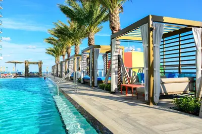 a resort with a pool and palm trees at Modern Beachside Condo W Ocean Views in Hollywood
